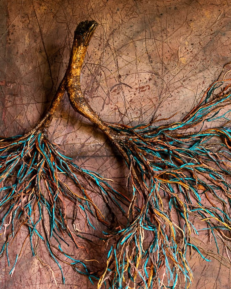Detail van een wortelwerk met blauwe en aardkleurige vezels